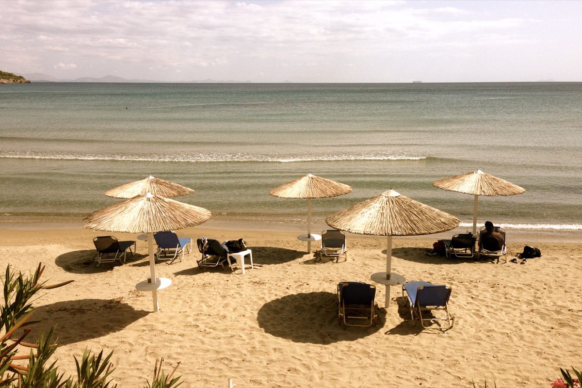 Goldfinger was here?! - wie vergoldet: Die Sonnenschirme am Strand in der Hauptstadt Ägina auf der griechischen Insel Ägina.