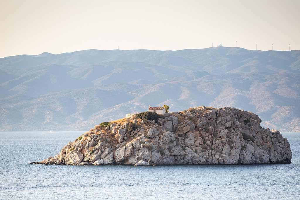 Ein felsiges Kleinod mit einer Kapelle vor der saronischen Insel Hydra in Griechenland (Foto: Church island Hydra, 16 July 2018, dronepicr, CC BY 2.0 https://creativecommons.org/licenses/by/2.0, via Wikimedia Commons).