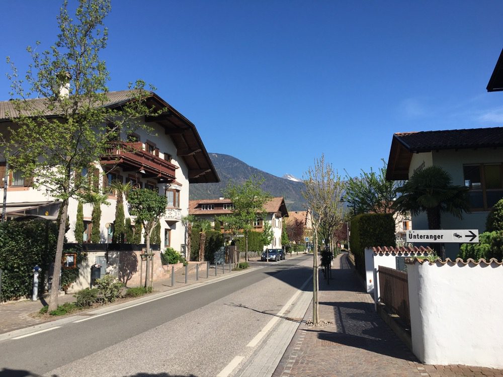 Ein Blick in die Schnatterpeckstraße in Niederlana in der Ortschaft Lana. Links geht es zur Frühstückspension ‘Unteranger‘ (Lana, Meraner Land, Südtirol, 18.04.2022).