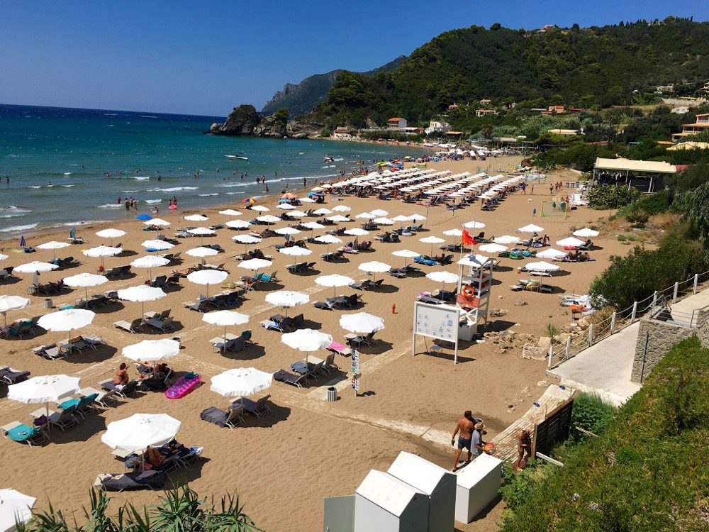 Durch den Dschungel gespäht: Der Strand Kontogialos Beach an der Westküste der griechischen Insel Korfu (Korfu, Ionische Inseln, Griechenland, 15.08.2022). 