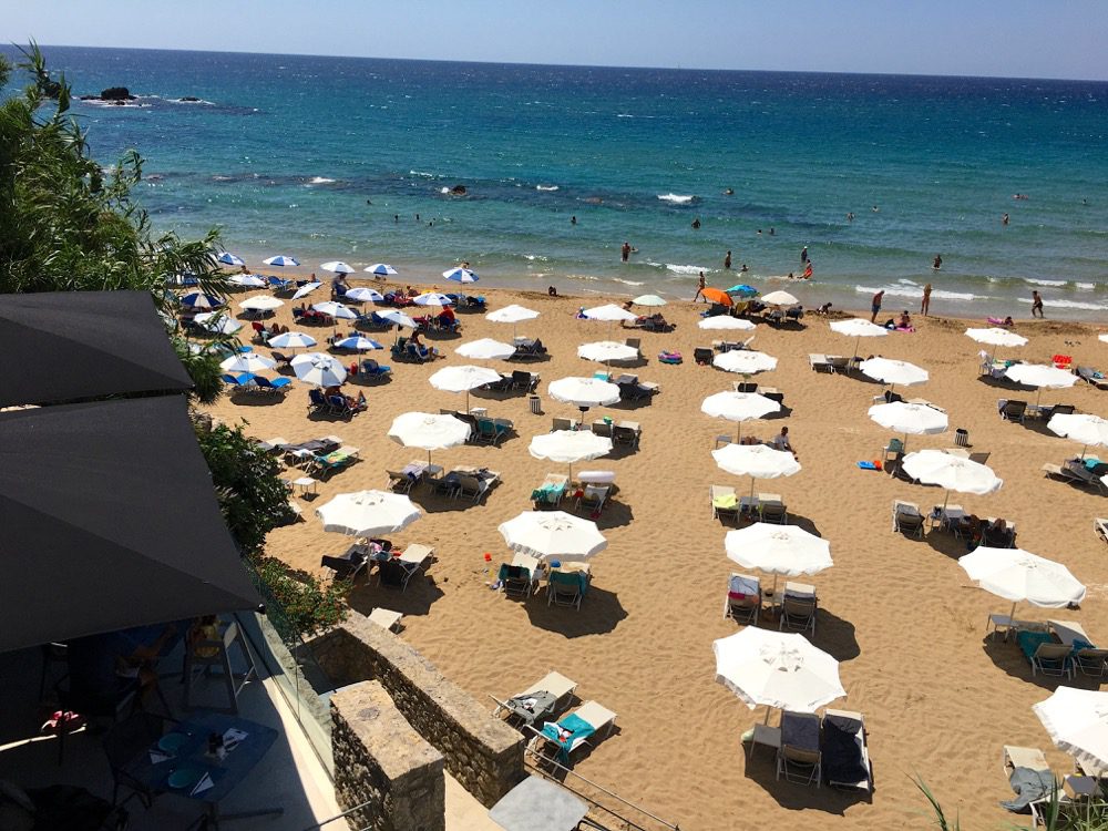 Durch den Dschungel gespäht: Der Strand Kontogialos Beach an der Westküste der griechischen Insel Korfu (Korfu, Ionische Inseln, Griechenland, 15.08.2022). 