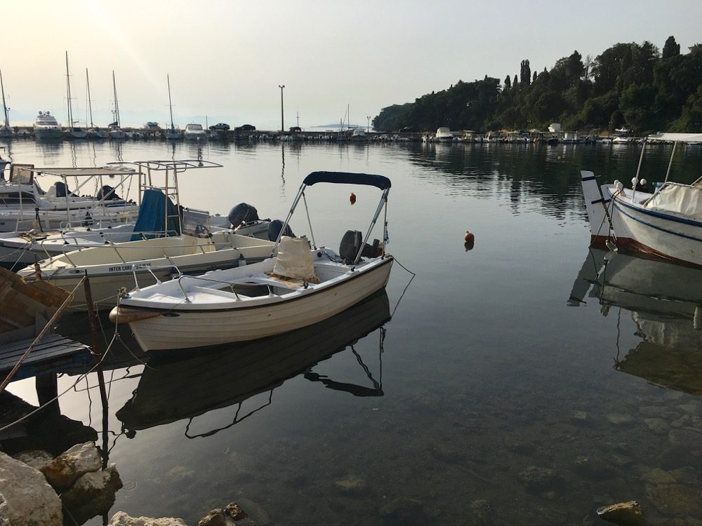 Wie ausgestorben: Der Hafen und der Strand in Ipsos an der Ostküste von Korfu (Korfu, Ionische Inseln, Griechenland, 18.08.2022).